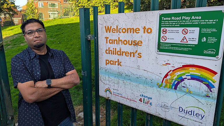 Cllr Kash Khan at the gate of the park